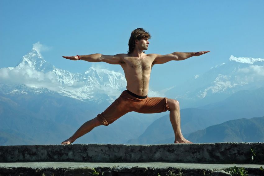 Man practicing yoga in Himalaya mountains, with view of Machapuchare, Nepal